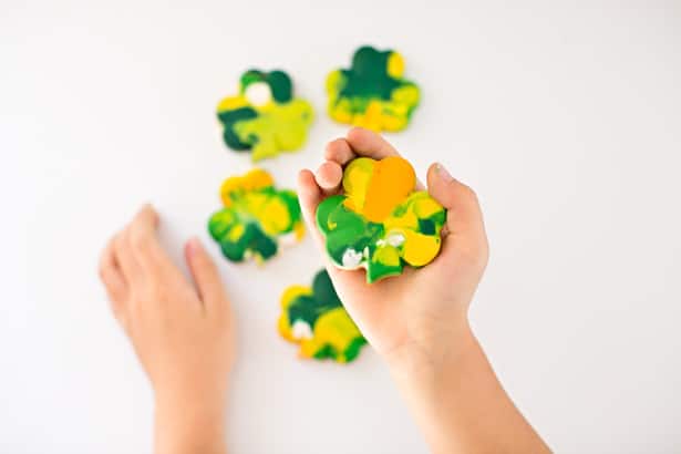 child holding ST. PATRICK'S DAY SHAMROCK CRAYONS