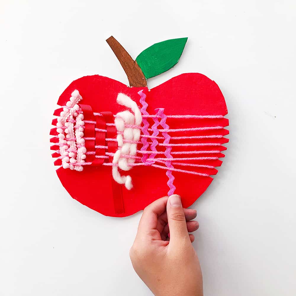 Ring in fall with an artful cardboard apple weaving craft for kids! A wonderful arts and crafts activity and fine motor skill practice. 