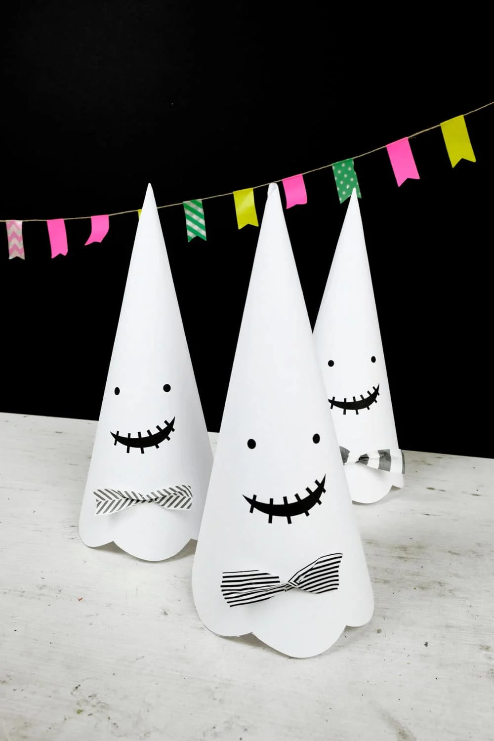 Cute Halloween paper cone ghosts (free template included).