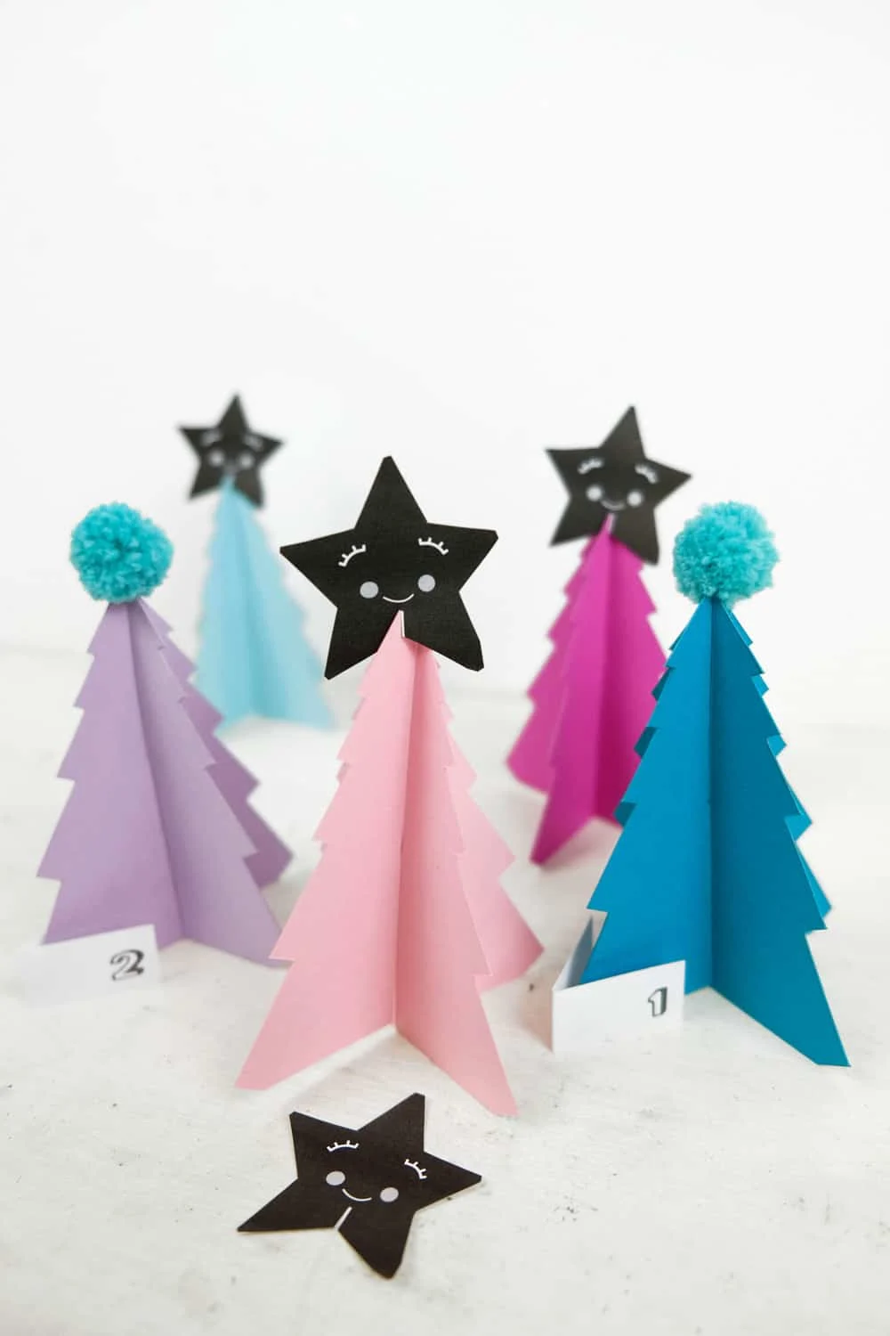 Create your own holiday countdown and use colorful pom poms to decorate these bright trees paper trees (free template included). 