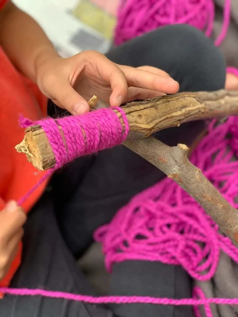 wrapping yarn around stick to make yarn letters