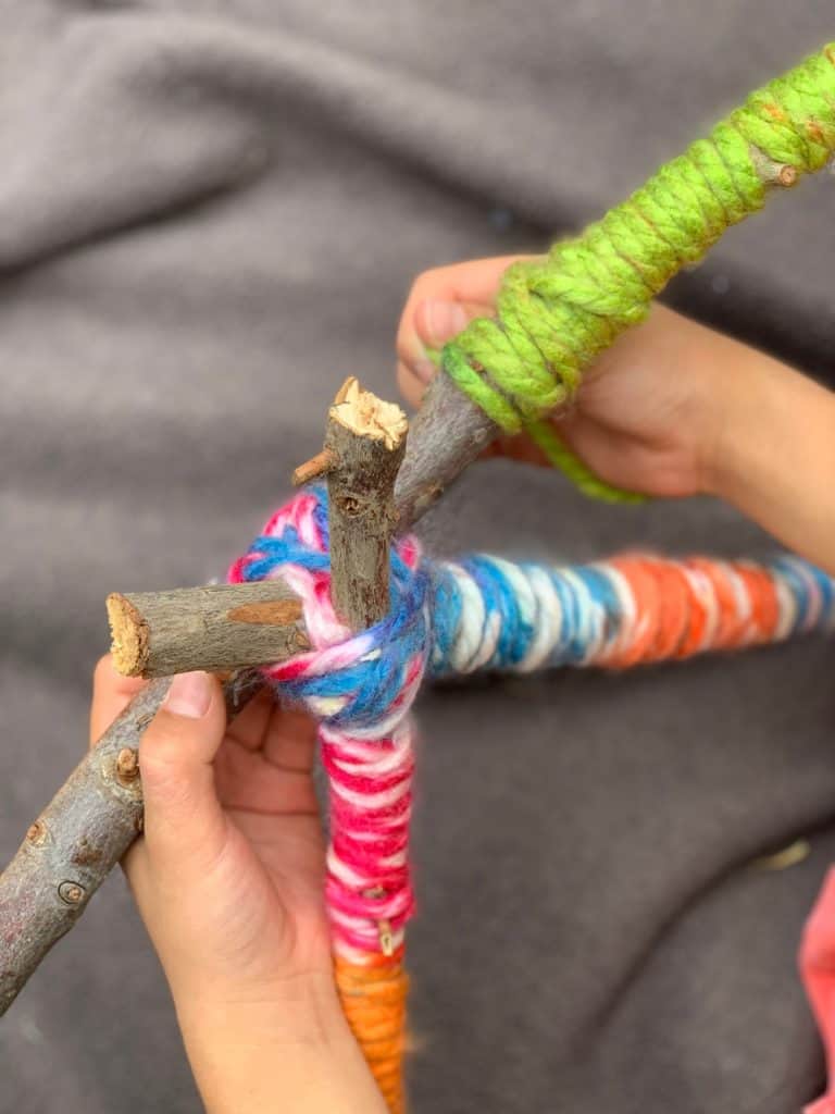 wrapping yarn around stick to make yarn letters