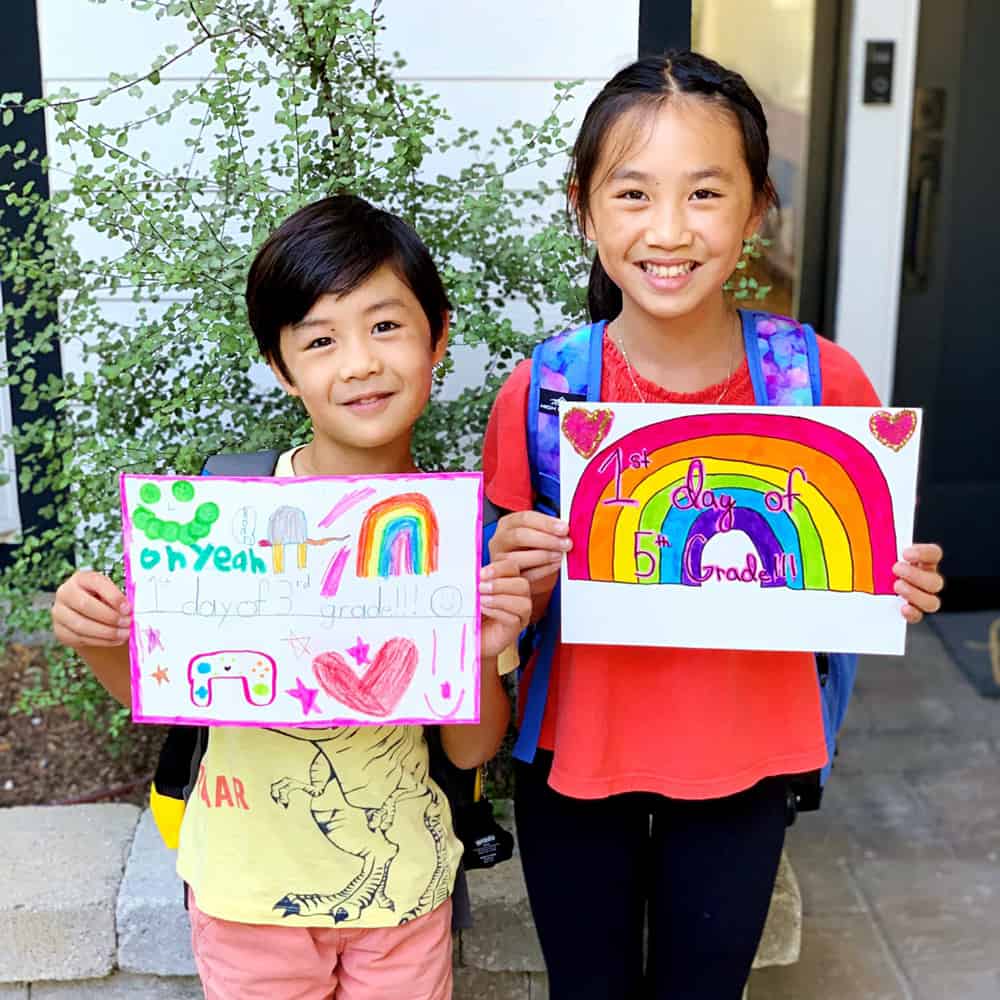 Kids holding back to school sign to remember each year