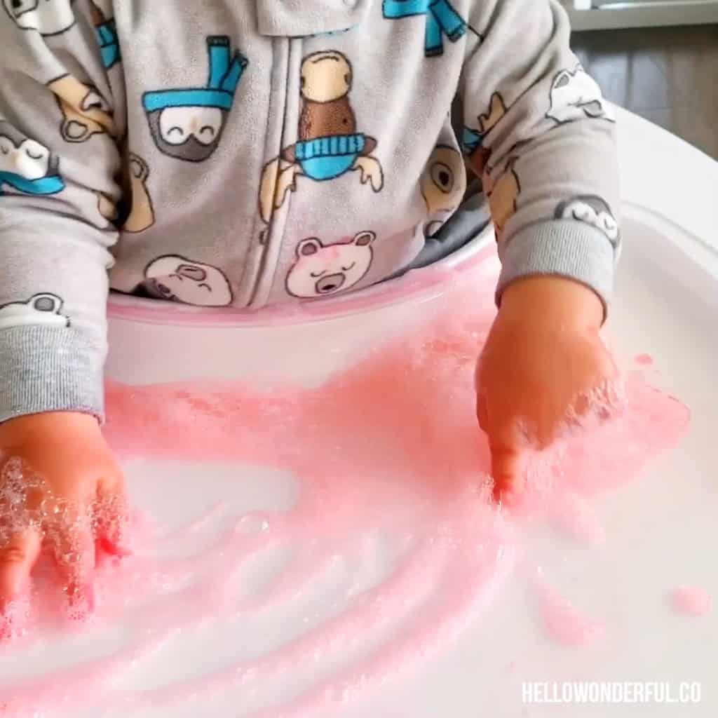 toddler fingers playing with bubble solution 