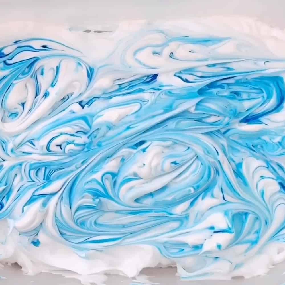 shaving cream and blue food coloring in a bin