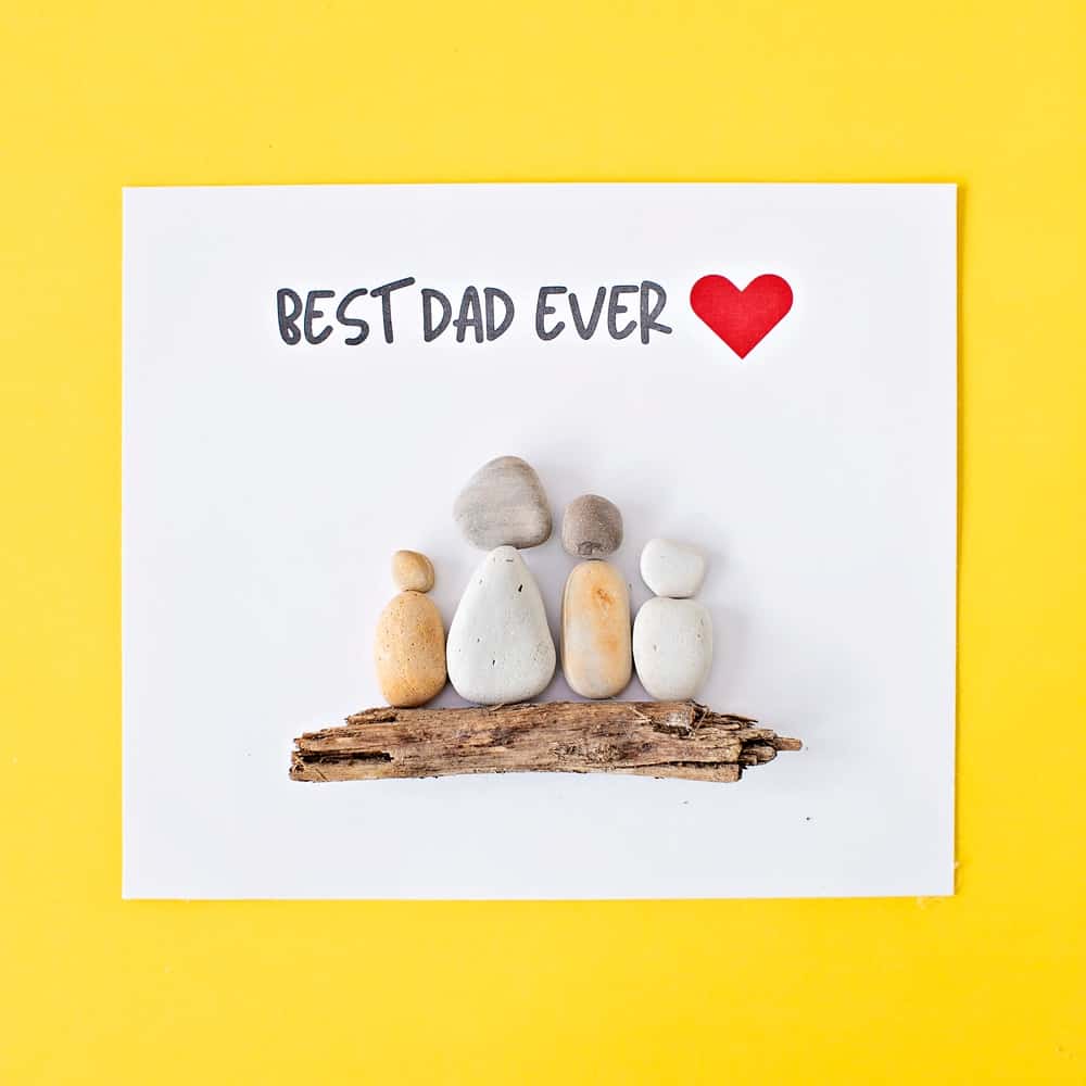 pebble rock art on yellow background for father's day that says best dad ever