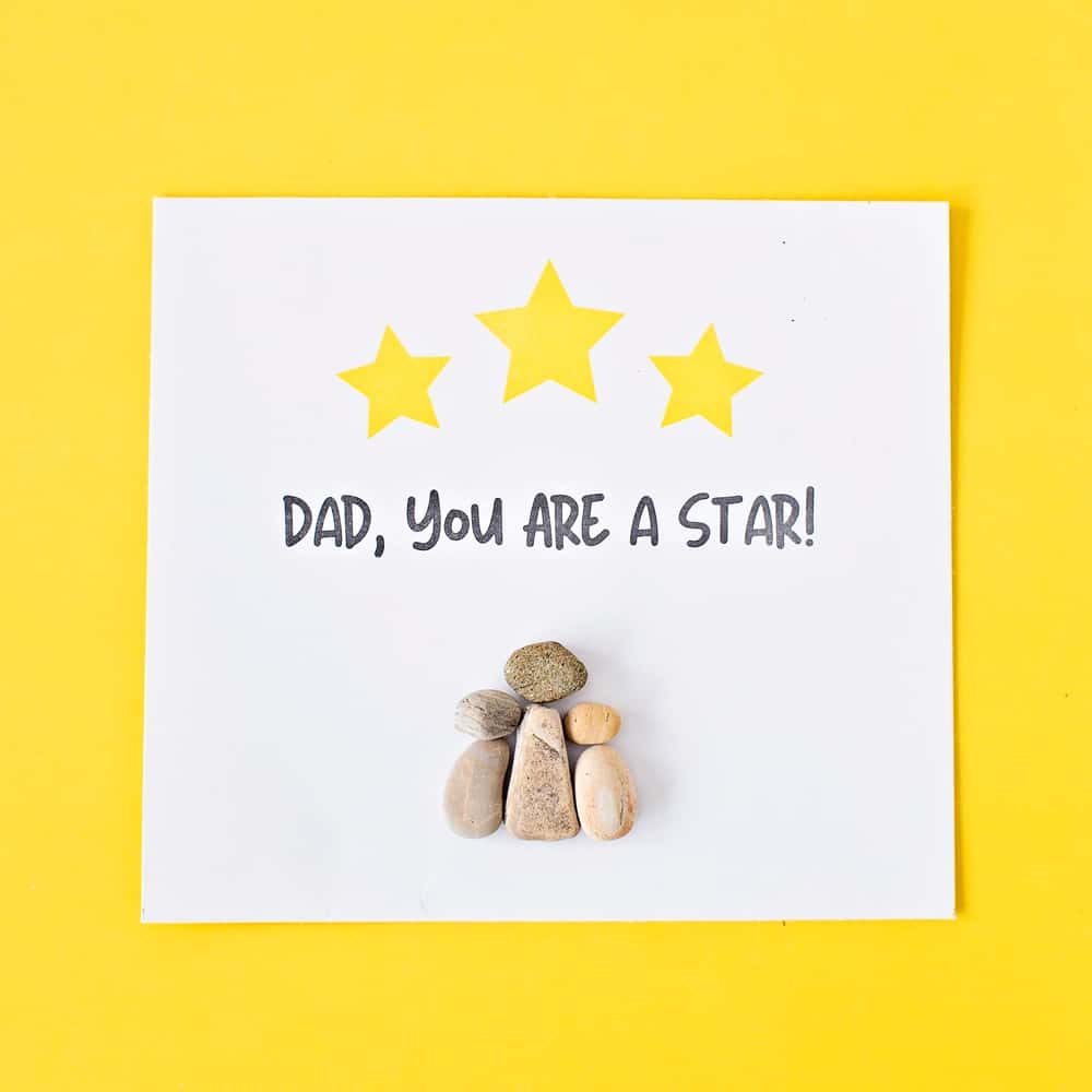 pebble rock art on yellow background for father's day that says dad you are a star