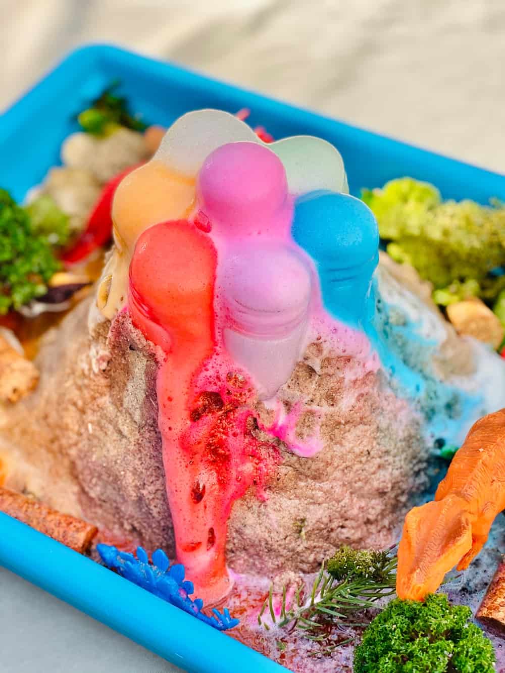 Rainbow Baking Soda Volcano Experiment. Sand around tubes as the volcano in a blue plastic bin. 