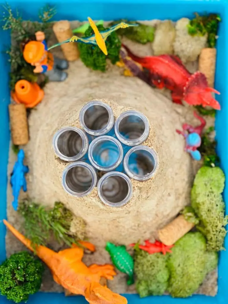 plastic test tubes around sand forming a volcano