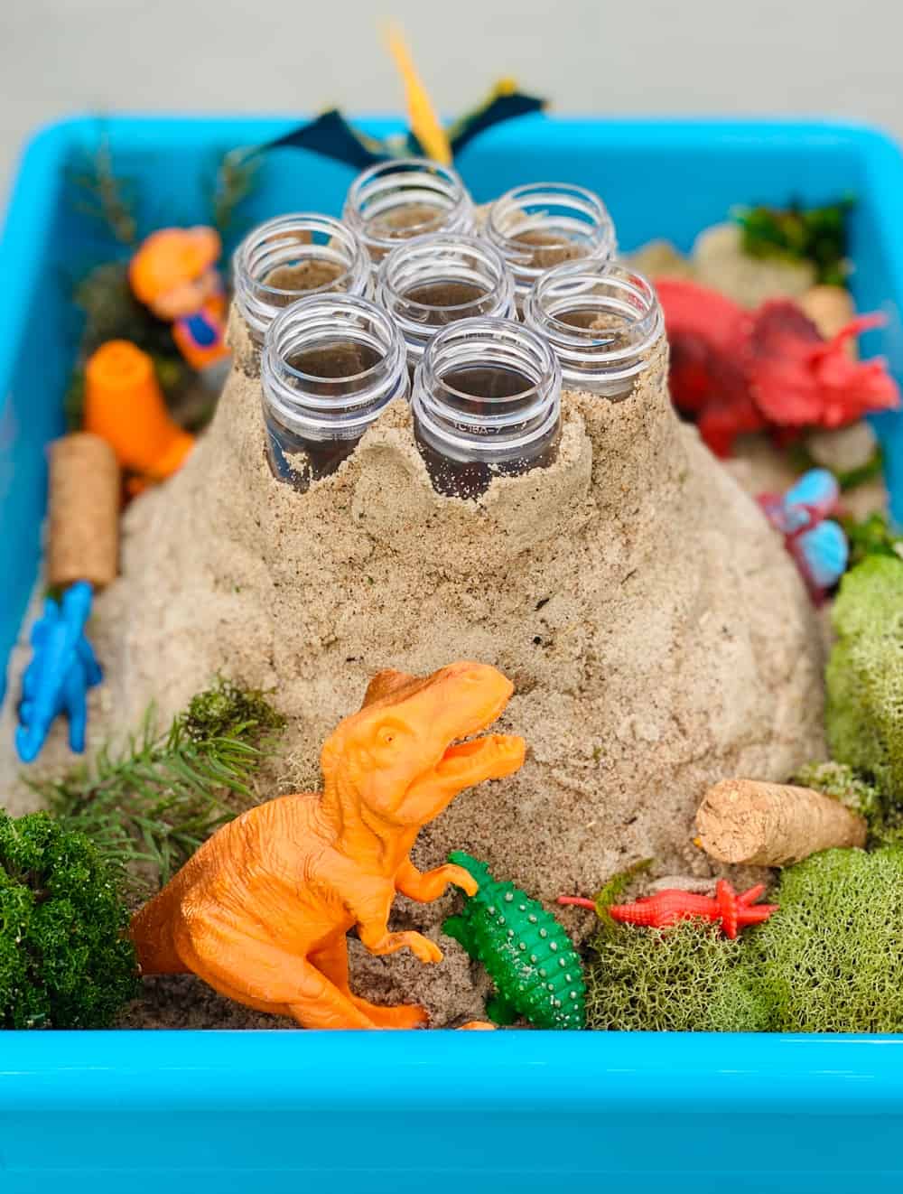 plastic test tubes around sand forming a volcano