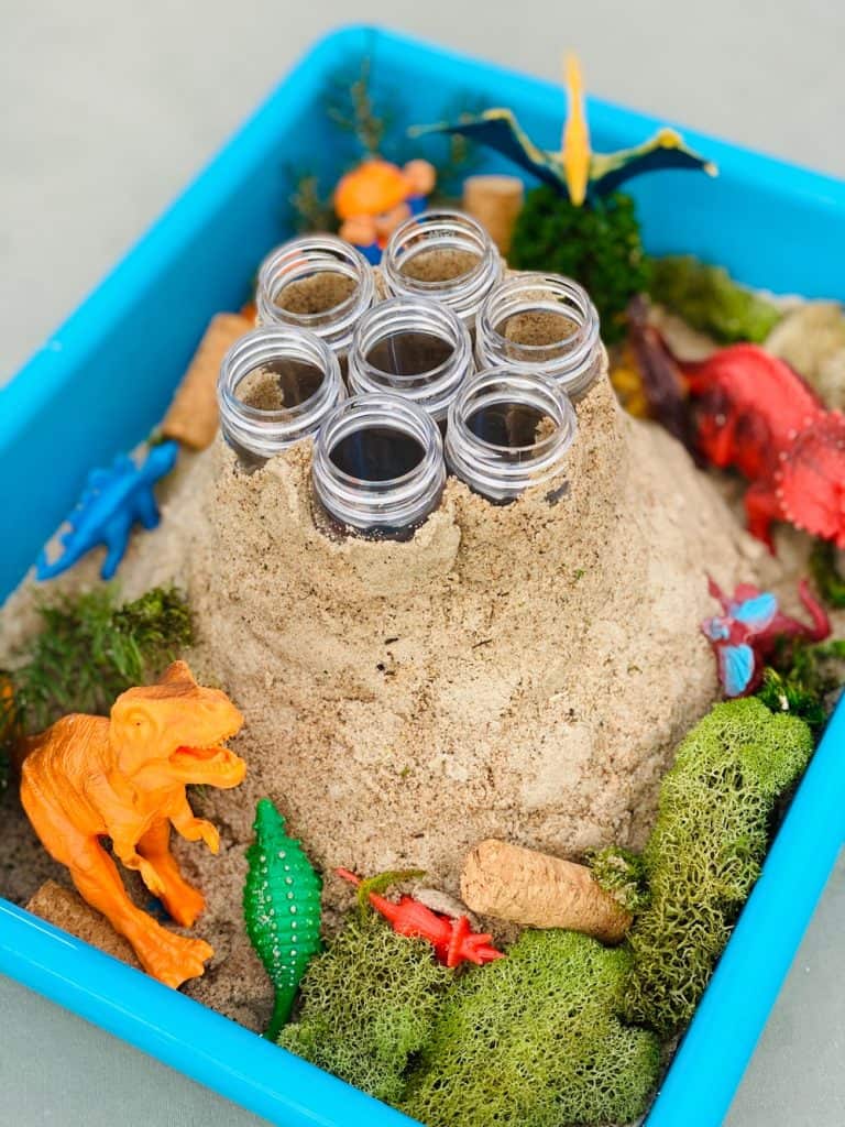 plastic test tubes around sand forming a volcano