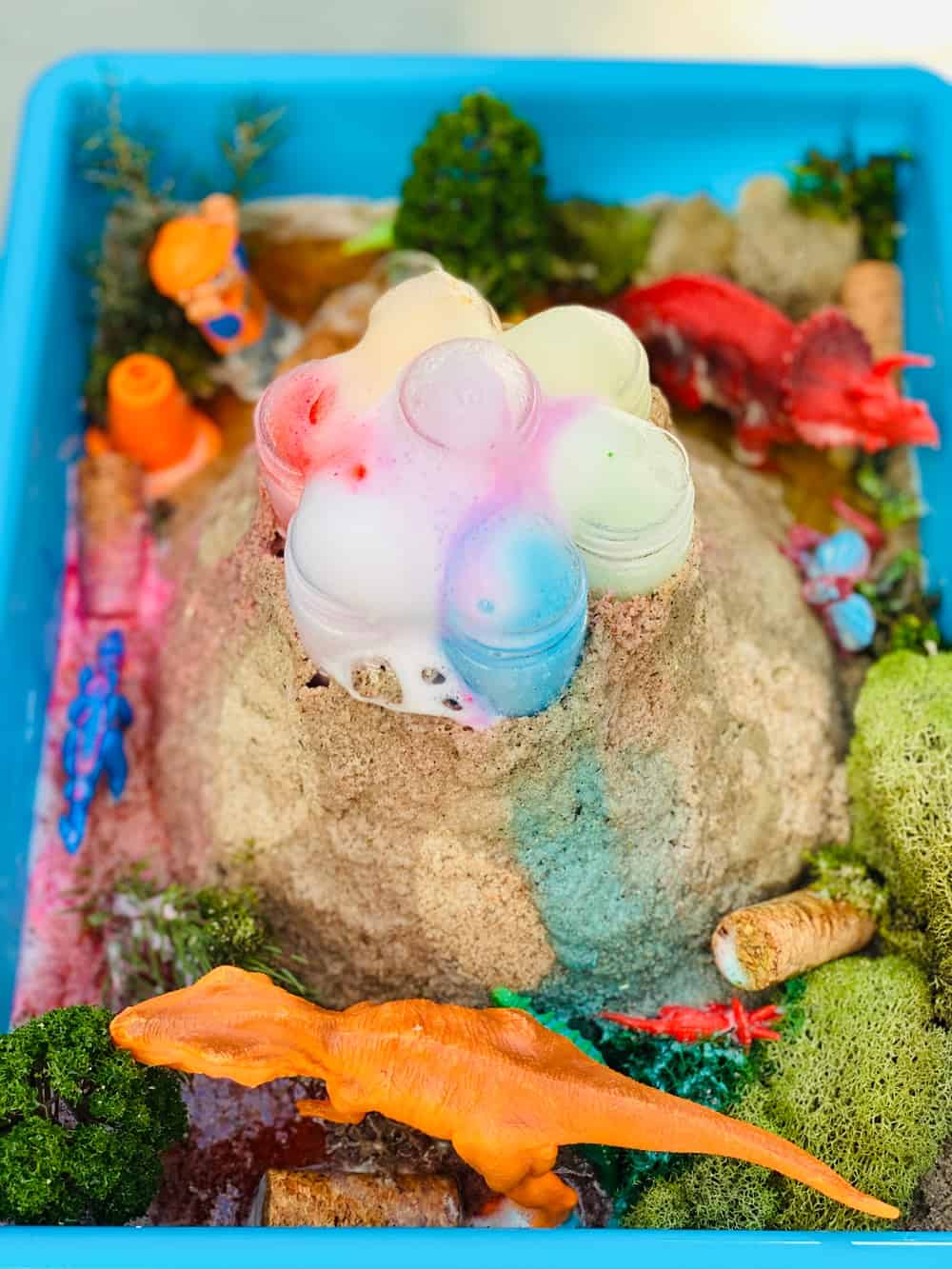 rainbow baking soda volcano science experiment for kids with toy dinosaurs