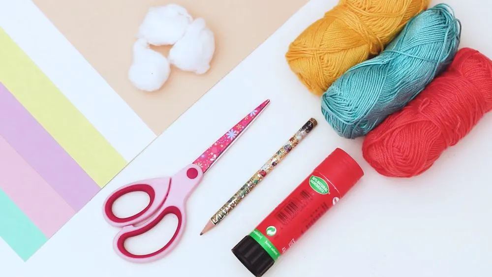materials for paper ice cream craft like yarn, paper, cotton balls, scissors, glue
