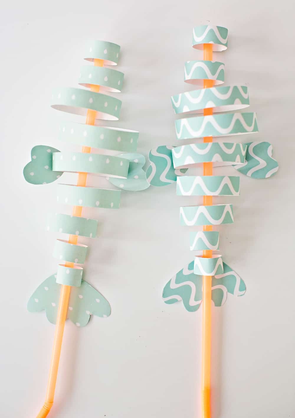 fish paper craft made from colorful strips of blue paper and straws 