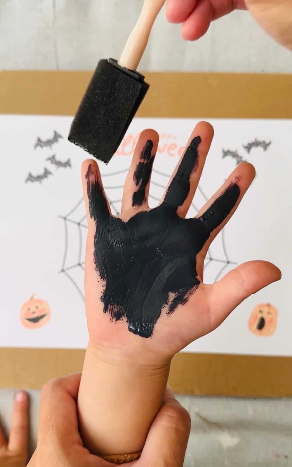 painting handprint black to make spider art